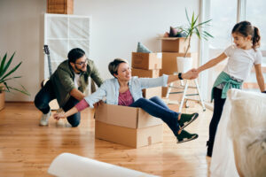 Happy parents and daughter having fun while moving into a new home.